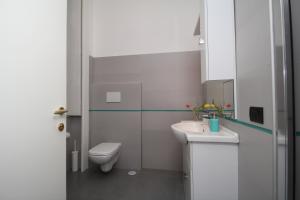 La salle de bains blanche est pourvue de toilettes et d'un lavabo. dans l'établissement Angoletto Young B&B, à Avellino