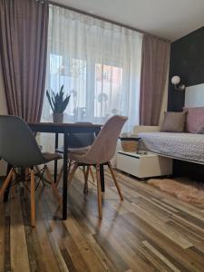 a living room with a table and chairs and a bed at FRIZ&FANY Postojna City Center in Postojna