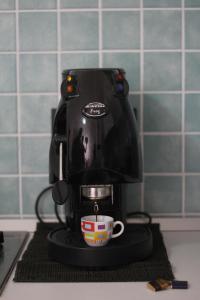 a black coffee maker with a cup on a counter at Angoletto Young B&B in Avellino