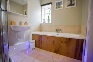 uma casa de banho com uma banheira e um lavatório em Luxury Home - Hot Tub - Pool Table - Cinema Room - Close to Beach em Bournemouth