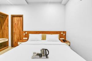 OYO Townhouse 801 The Circle في جايبور: غرفة نوم بها سرير مع وجود ماكينة خياطة