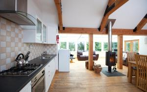 cocina con electrodomésticos blancos y sala de estar. en The Byre, Back Borland Holday Cottages en Stirling