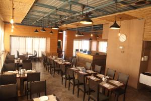 a dining room with tables and chairs and a clock at Hotel Grand Ecotel, Aurangabad in Aurangabad