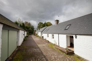 rząd białych budynków zaparkowanych obok siebie w obiekcie The Byre, Back Borland Holday Cottages w mieście Stirling