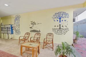 a room with chairs and a wall with a tree on it at OYO SilverKey 2d Residency in Irugūr