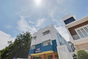 a white and blue building with the sun in the sky at OYO SilverKey 2d Residency in Irugūr