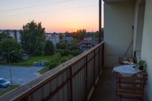 a balcony with a view of a sunset at Warm & Cozy Apartment with balcony in Valmiera in Valmiera