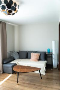 uma sala de estar com um sofá e uma mesa em Warm & Cozy Apartment with balcony in Valmiera em Valmiera