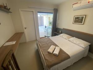 una camera da letto con un letto e due asciugamani di Vila das Dunas - aluguel de temporada a Cabo Frio