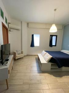 1 dormitorio con 1 cama, TV y sofá en Dimora Anna, en Termoli