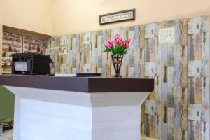 un vestíbulo con un mostrador con un jarrón de flores en SPOT ON Hotel Poonam, en Jagdalpur