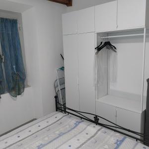 a bedroom with a bed and a white wall at ANFORA HOUSE in Genoa