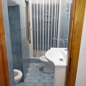 ein Badezimmer mit einem weißen Waschbecken und einem WC in der Unterkunft ANFORA HOUSE in Genua