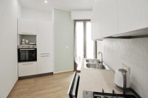 a white kitchen with a sink and a stove at [Relax-Comfort-Home] City Center in Porto Torres