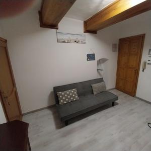 a living room with a couch and a wooden door at ANFORA HOUSE in Genoa