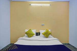 a bed with yellow walls and yellow pillows on it at SPOT ON Raj Hotel Vip Near Worlds Of Wonder in Kalkaji Devi