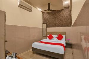 a bedroom with a large bed with red pillows at Flagship Nandi Palace Lodging And Boarding in Mumbai