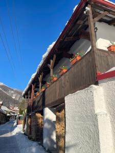 a building with a wooden roof in the snow at Chalupa pri Čerešni “Moja srdcovka” in Staré Hory