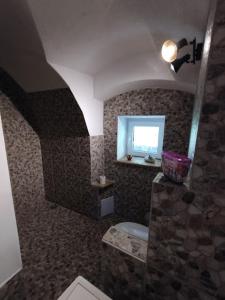 a bathroom with a stone shower with a toilet at Chalupa pri Čerešni “Moja srdcovka” in Staré Hory