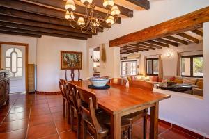 cocina y comedor con mesa de madera y sillas en Casa Linda, en San José