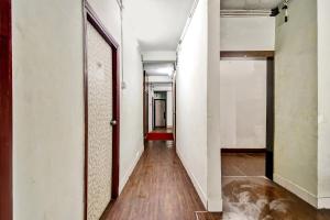 an empty hallway with white walls and wooden floors at Collection O Hotel Lemon Arrow Inn in Howrah