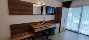 Zimmer mit einem Schreibtisch, einem Stuhl und einem TV in der Unterkunft KAPTAN HAN Boutique hotel in Kazıklı