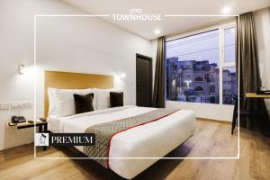 a hotel room with a bed and a large window at Super townhouse moosapet Rcc Prime in Hyderabad