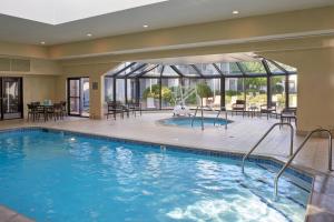 a pool in a hotel with tables and chairs at Sonesta Select Minneapolis Eden Prairie in Eden Prairie