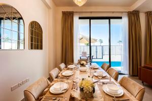 a dining room with a long table and chairs at Luxury Villas with Beach Access by VB Homes in Ras al Khaimah