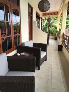 een veranda met rieten stoelen en een tafel bij Villa Jaya in Lovina