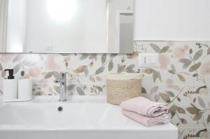 a bathroom sink with pink towels and a mirror at [Relax-Comfort-Home] City Center in Porto Torres