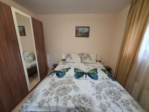 - une chambre dotée d'un lit avec des papillons dans l'établissement Апартамент Зимна приказка, à Chepelare