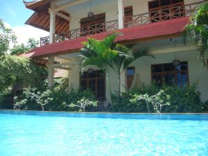 a house with a swimming pool in front of it at Villa Jaya in Lovina