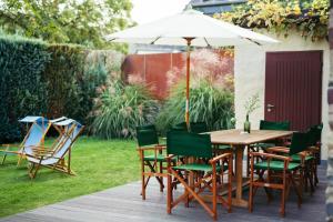森海姆Senhalser Höfe的一张木桌和椅子及雨伞