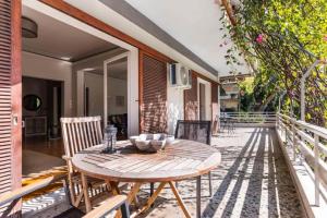 Spacious renovated flat in the Athens Riviera في أثينا: طاولة وكراسي خشبية على الفناء