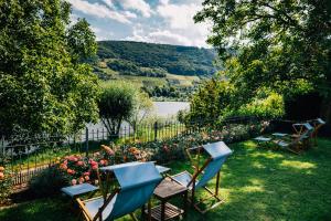 a yard with chairs and flowers and a lake at Senhalser Höfe in Senheim