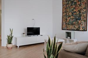 a living room with a tv on a white cabinet at [Relax-Comfort-Home] City Center in Porto Torres