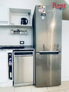 eine Küche mit einem Kühlschrank aus Edelstahl und einem Geschirrspüler in der Unterkunft Rent Plaza in Buenos Aires