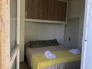 ein kleines Bett in einem kleinen Zimmer mit einem Schrank in der Unterkunft Sandilos in Sorso