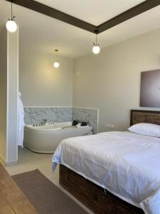 منتجع جبل رثباء Rathba Mountain Resort في السودة: غرفة نوم مع سرير وحوض استحمام