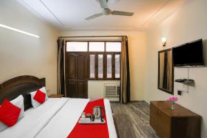 a hotel room with a bed and a television at Flagship Av Homes Near Aravali Biodiversity Park in Gurgaon