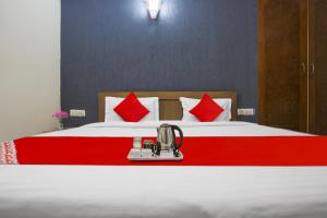 1 dormitorio con 1 cama grande con almohadas rojas en Flagship Av Homes Near Aravali Biodiversity Park, en Gurgaon