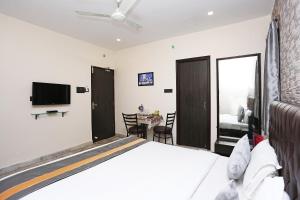 a bedroom with a bed and a table with chairs at Collection O Church View Near St. Thomas's Church in Kolkata