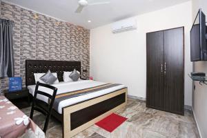 a bedroom with a bed and a chair in it at Collection O Church View Near St. Thomas's Church in Kolkata