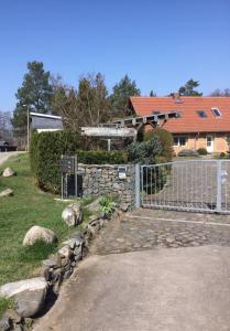 una cerca frente a una casa con un patio en Ferienwohnung am Netzener See, en Netzen