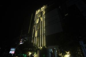 um edifício alto com luzes acesas à noite em Townhouse Hotel Eaglewood Gachibowli em Kondapur