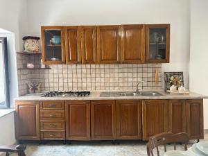una cocina con armarios de madera y fregadero en Vicolo18 Tropea en Tropea