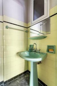 baño con lavabo verde y espejo en Spacious renovated flat in the Athens Riviera en Atenas