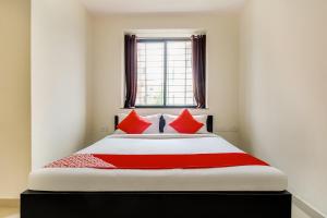 una camera da letto con un grande letto con cuscini rossi di OYO Hotel Galaxy Near INOX a Yeraoda