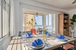 un comedor con una mesa con gafas y servilletas azules en Apartment in Algarrobo Costa en Algarrobo-Costa